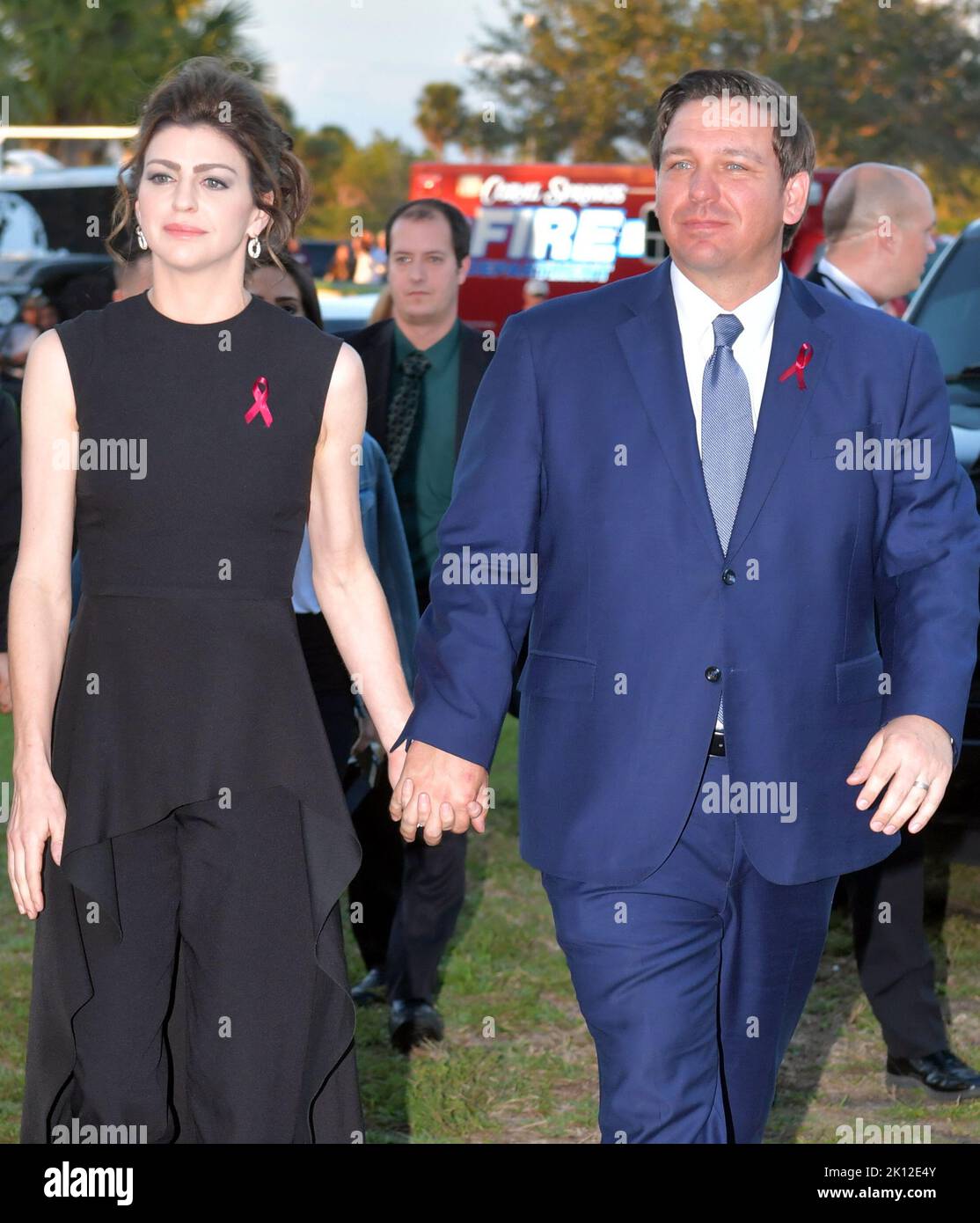 PARKLAND, FL - FEBRUARY 14: Gov Ron DeSantis and wife Casey DeSantis watch ceremony with tears in their eyes. Seventeen people were shot and killed by an ex-student at Marjory Stoneman Douglas High School (MSD) in Parkland, Florida on 14 February 2018. Students and educators across the country are also marking the day with vigils, moments of silence, art projects and other demonstrations. Police originally arrested 19-year-old former student Nikolas Cruz for killing 17 people at the Marjory Stoneman Douglas High School, at Pine Trail Park on February 14, 2019 in Parkland, Florida   People:  Go Stock Photo