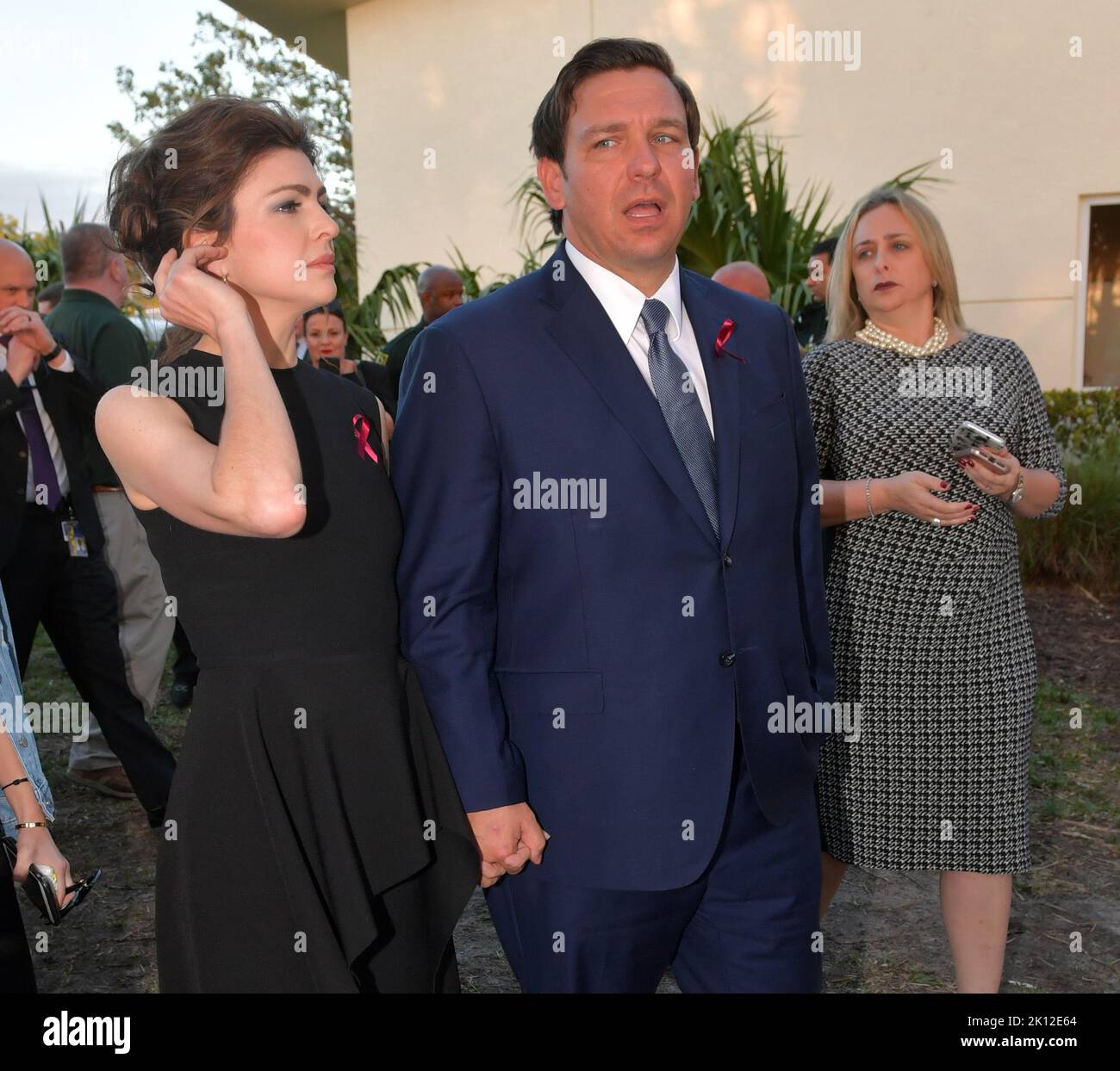 PARKLAND, FL - FEBRUARY 14: Gov Ron DeSantis and wife Casey DeSantis watch ceremony with tears in their eyes. Seventeen people were shot and killed by an ex-student at Marjory Stoneman Douglas High School (MSD) in Parkland, Florida on 14 February 2018. Students and educators across the country are also marking the day with vigils, moments of silence, art projects and other demonstrations. Police originally arrested 19-year-old former student Nikolas Cruz for killing 17 people at the Marjory Stoneman Douglas High School, at Pine Trail Park on February 14, 2019 in Parkland, Florida   People:  Go Stock Photo