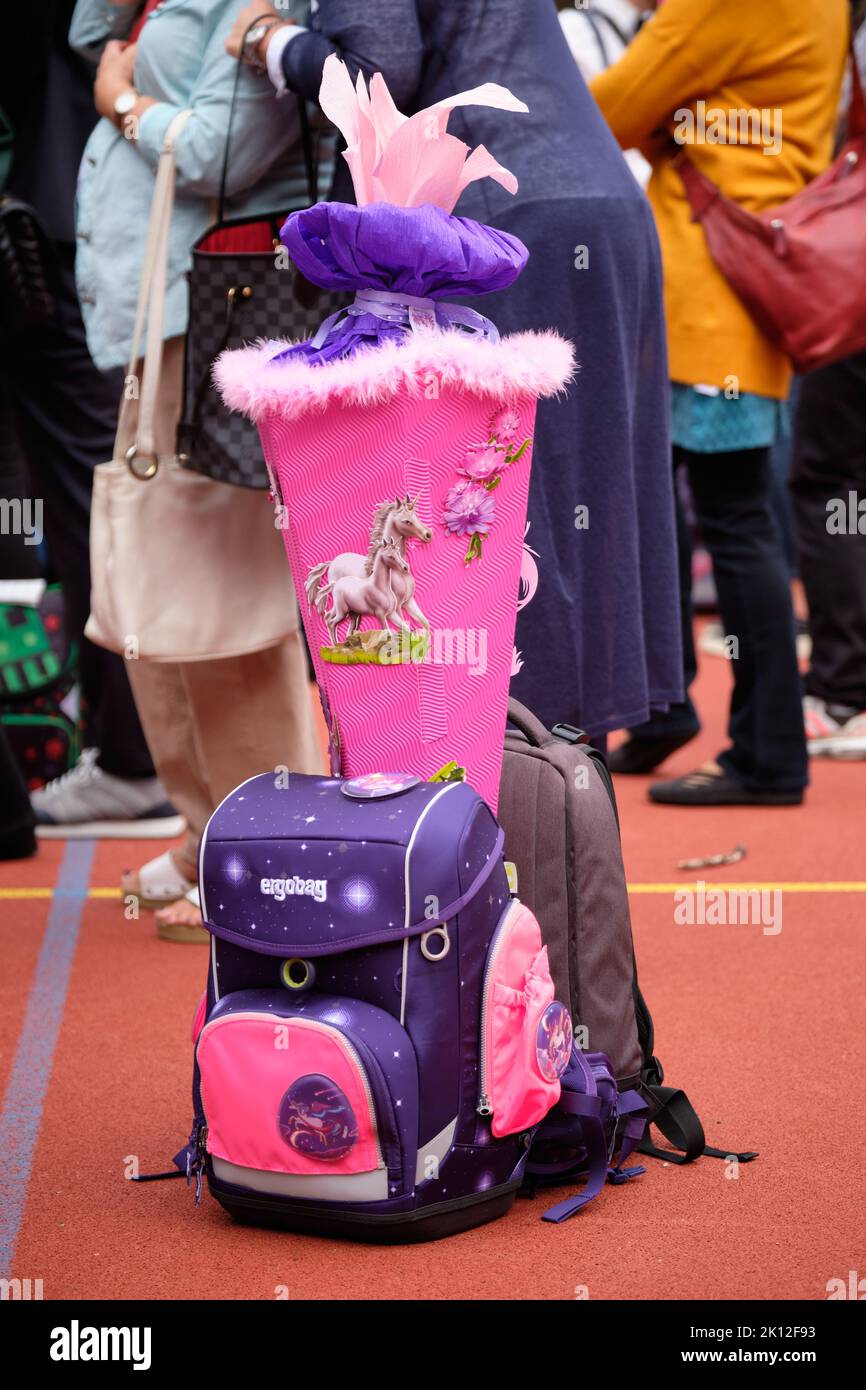 Nuremberg, Germany - August 13, 2022: Beautiful pink colored school cone with unicorns is standing between two school bags on the ground during school Stock Photo