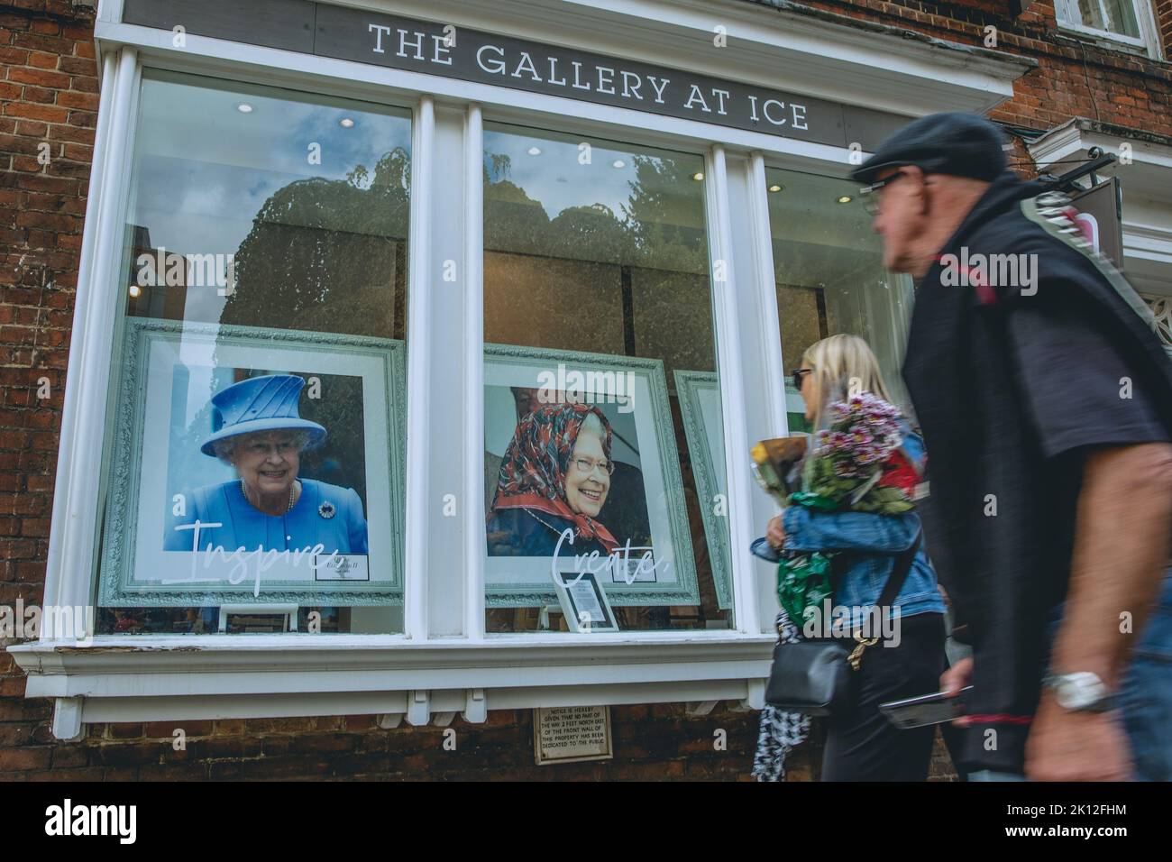 Windsor, UK. 14th September, 2022. Members of the public pass portraits of Queen Elizabeth II displayed in the windows of an art gallery. Queen Elizabeth II, the UK's longest-serving monarch, died at Balmoral aged 96 on 8th September after a reign lasting 70 years and will be buried in the King George VI memorial chapel in Windsor following a state funeral in Westminster Abbey on 19th September. Credit: Mark Kerrison/Alamy Live News Stock Photo