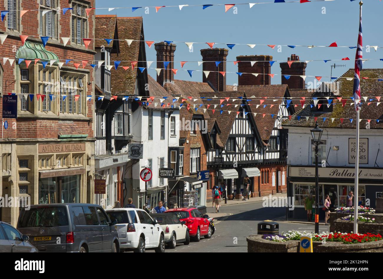 View down the High Street of Arundel in West Sussex, England. With parked cars and people walking around. Stock Photo