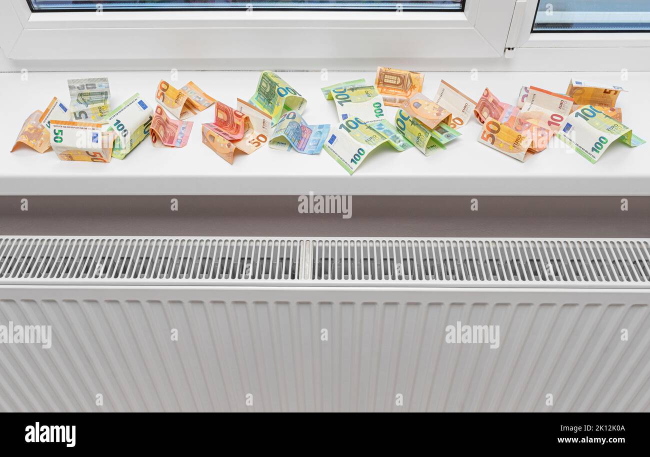 Money near the radiator. Expensive energy supply. Stock Photo