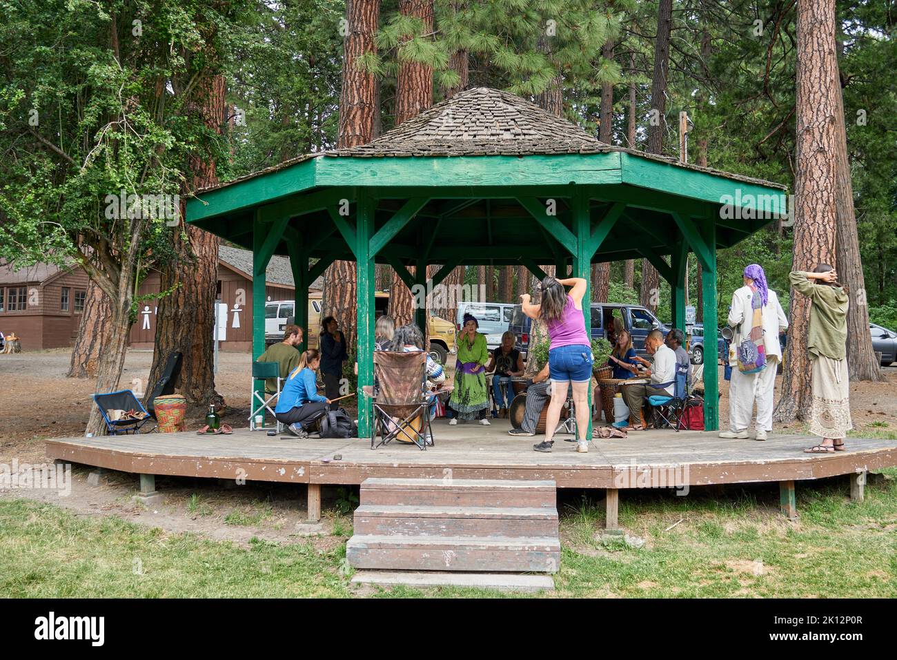 A gathering of hippies dancing and playing music at a park in Mount Shasta, California. Stock Photo
