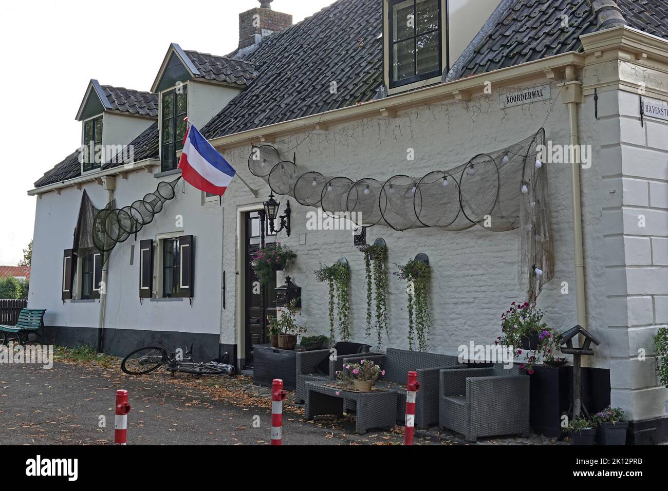 Elburg, the Netherlands - Sept. 9 2022 Historical old fisherman's house from the 19th century. It has a tiled roof black door and ... Stock Photo