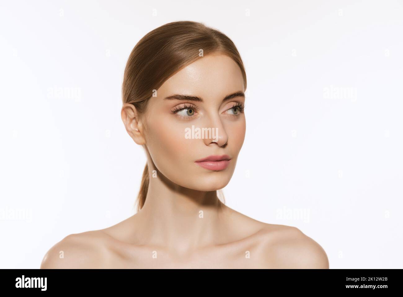 Portrait of young beautiful girl with wellkept skin and light daily makeup isolated on white