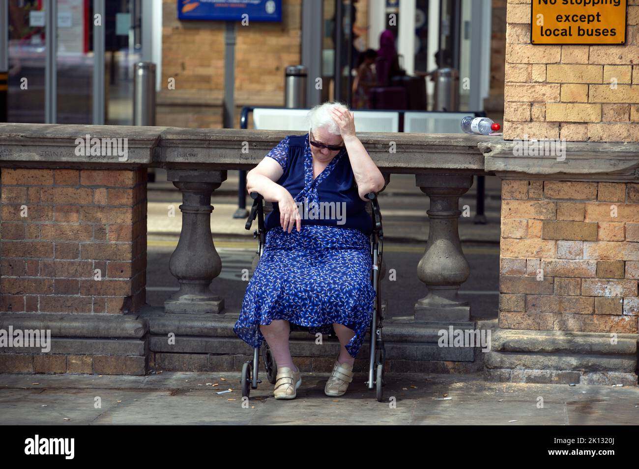 A woman waiting at a bus stop struggles with the heat as the people in the city of York, North Yorkshire endure the hottest day on record as the tempe Stock Photo