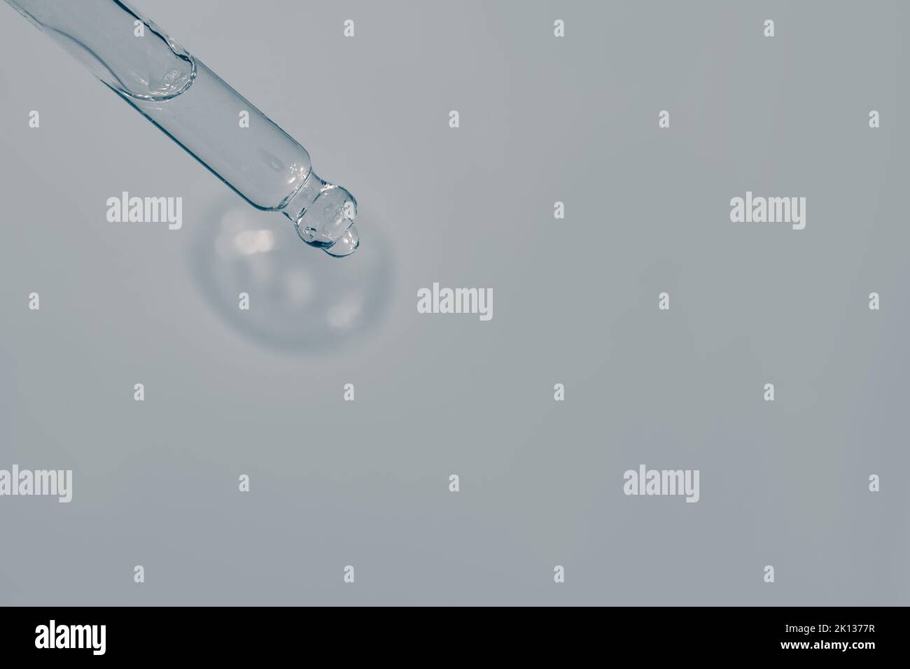 Liquid serum and dropper on a light blue background top view. Serum