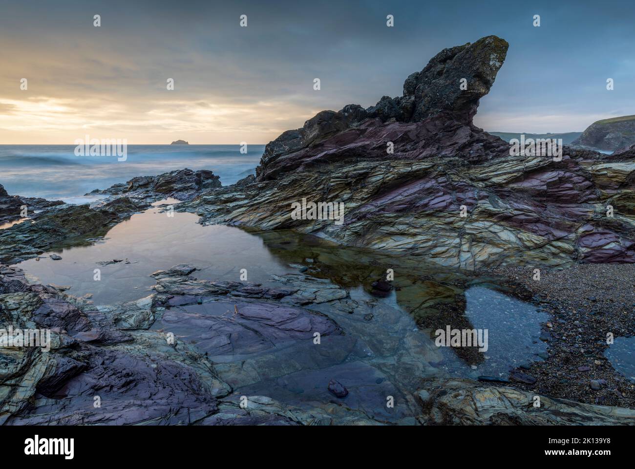 Purple coloured rocks on the Cornish shoreline at sunset, Polzeath, Cornwall, England, United Kingdom, Europe Stock Photo