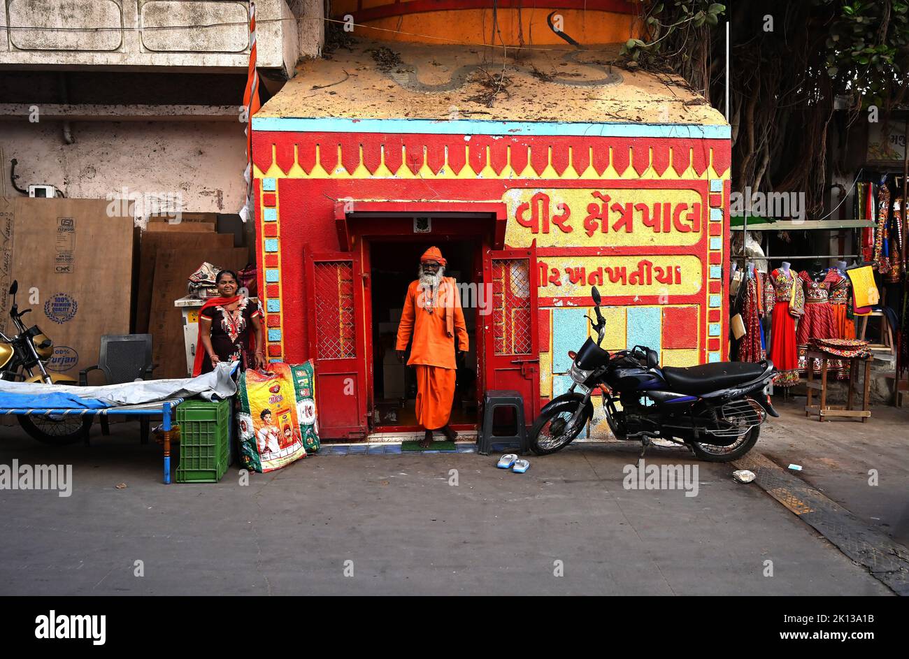 Hindu pundit dressed in holy orange at tiny Hindu temple near Gomati ghat, Dwarka, Gujarat, India, Asia Stock Photo