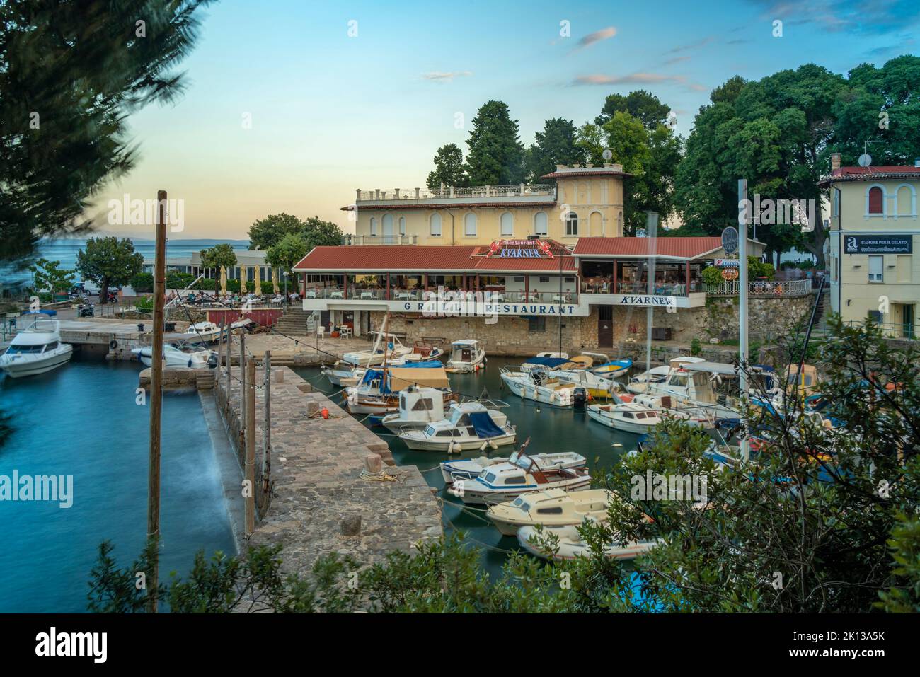 View of cafe and restaurant overlooking boats in harbour, Lovran village, Lovran, Kvarner Bay, Eastern Istria, Croatia, Europe Stock Photo