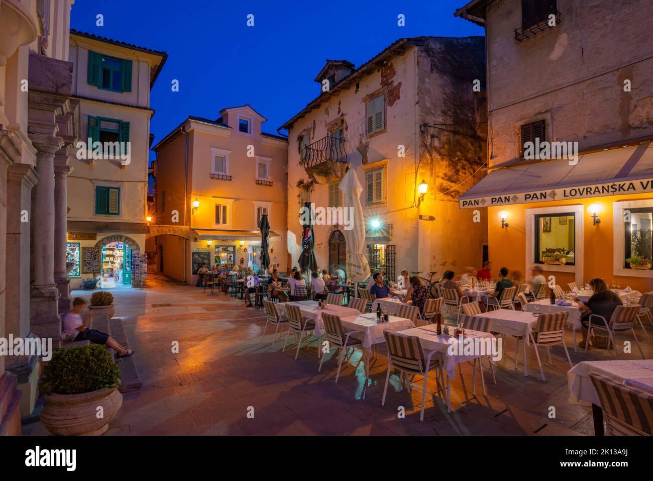 View of restaurants at dusk, Lovran, Kvarner Bay, Eastern Istria, Croatia, Europe Stock Photo