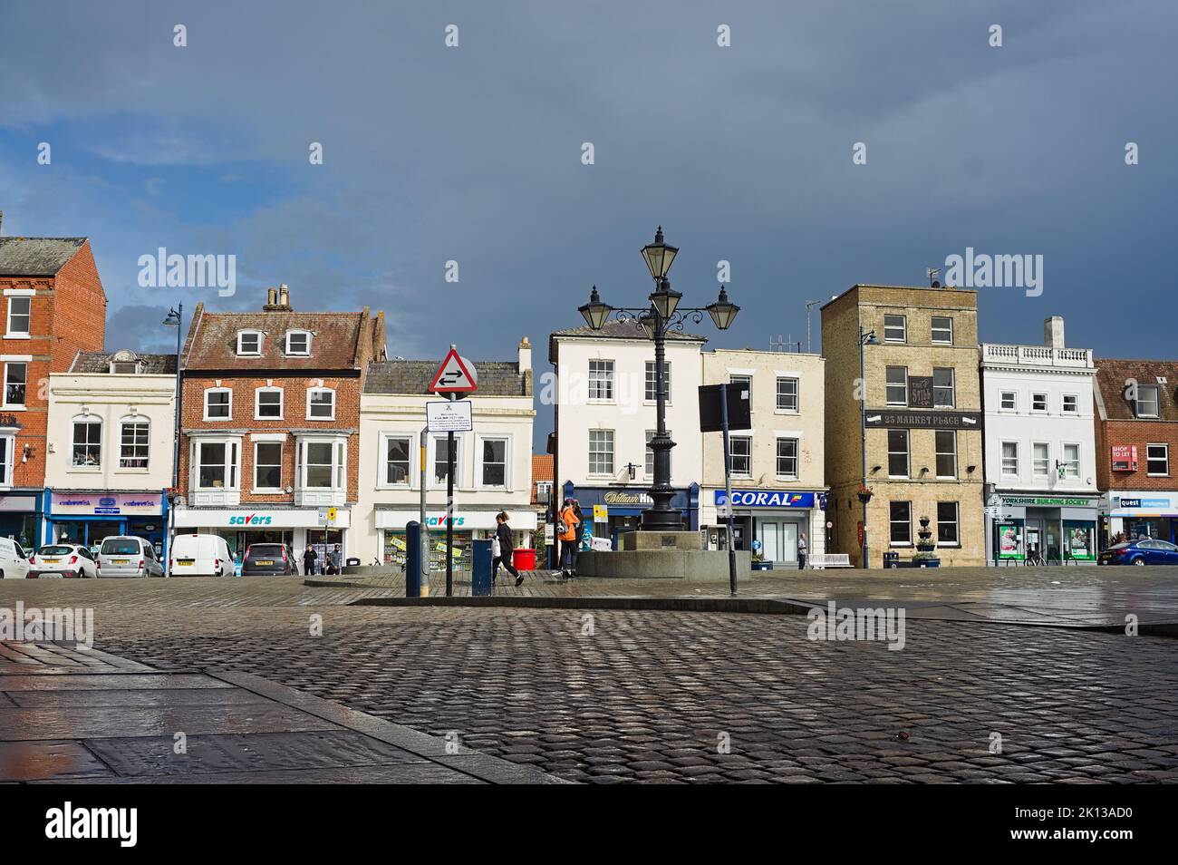 The marketplace during wet weather with a row of banks and shops. Stock Photo