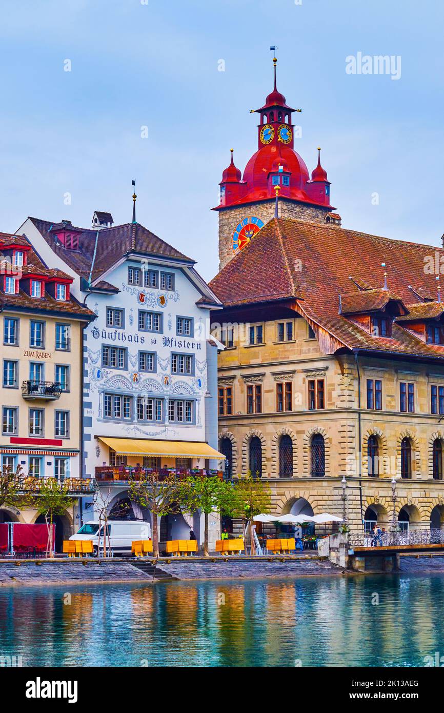 LUCERNE, SWITZERLAND - MARCH 30, 2022: The clock tower and old town hall on the bank of Reuss river, on March 30 in Lucerne, Switzerland Stock Photo