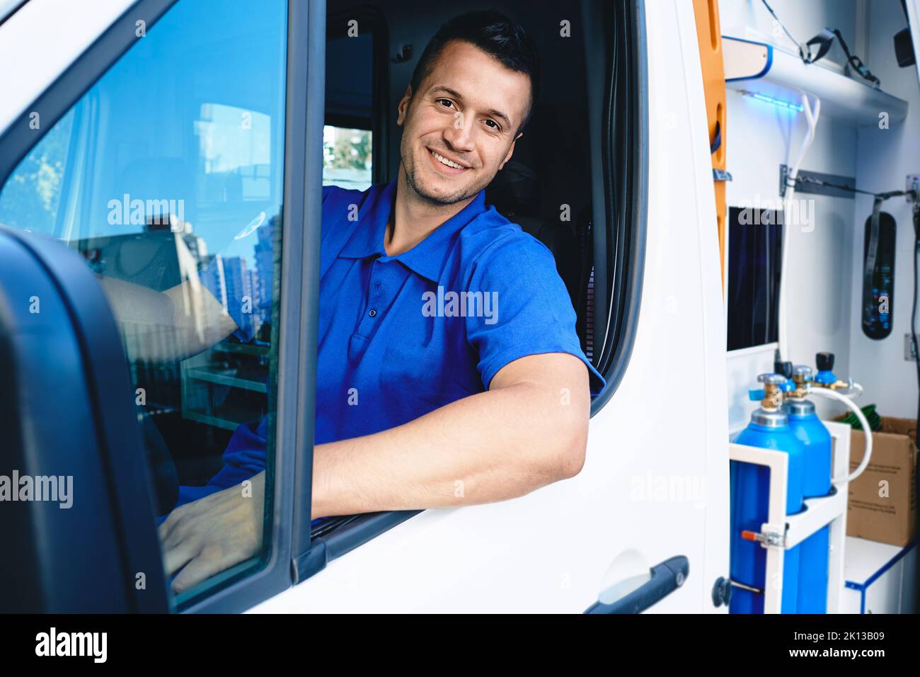 Emergency medical services worker. Portrait of male paramedic sitting inside ambulance Stock Photo