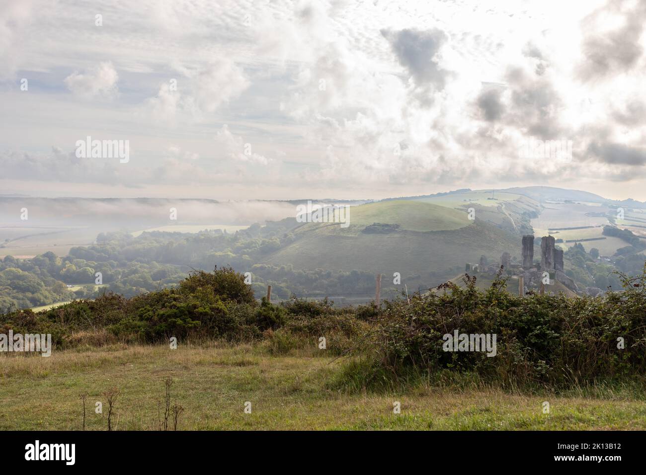 View of the Dorset countryside at Corfe on a misty morning with the castle ruins in the distance, England, UK Stock Photo