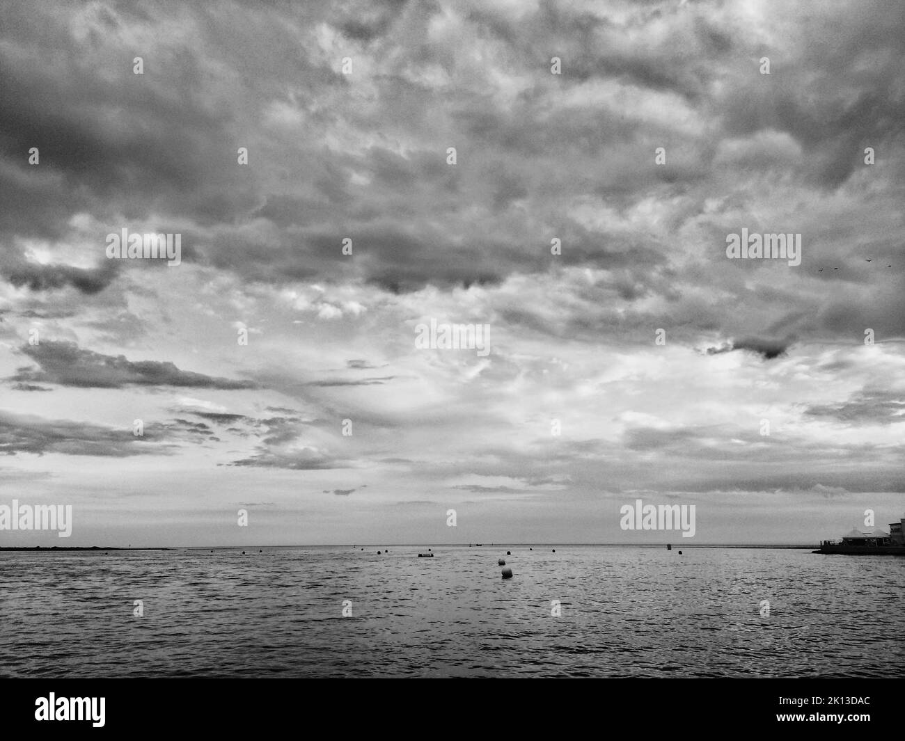 A grayscale shot of a sea view on a cloudy day Stock Photo - Alamy