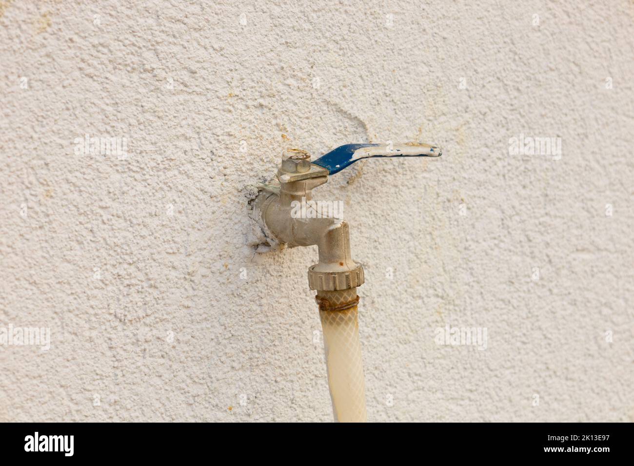 Faucet on the wall. Rusty blue garden faucet with hose attached Stock Photo Alamy