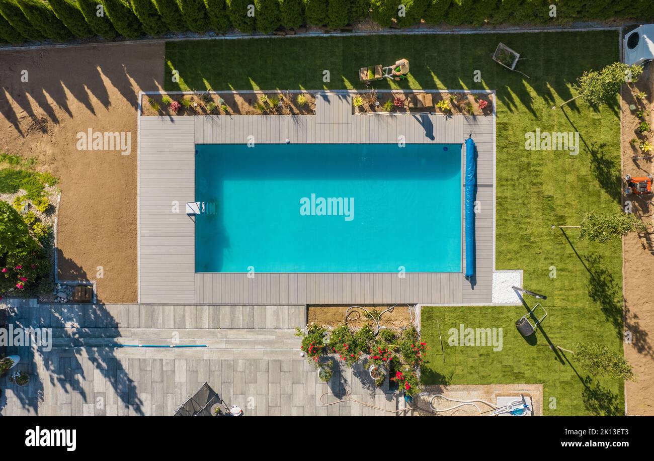 Residential Landscaping Industry Theme. Outdoor Swimming Pool Surroundings Natural Grass Installation. New Backyard Grass Lawn. Stock Photo
