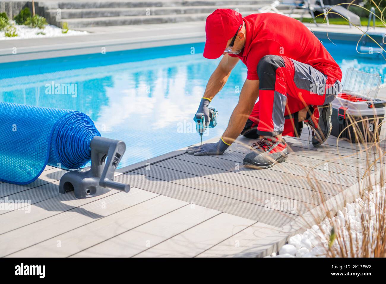Professional Swimming Pools Worker Finishing Composite Outdoor Pool Deck Installation. SPA Industry Theme. Stock Photo