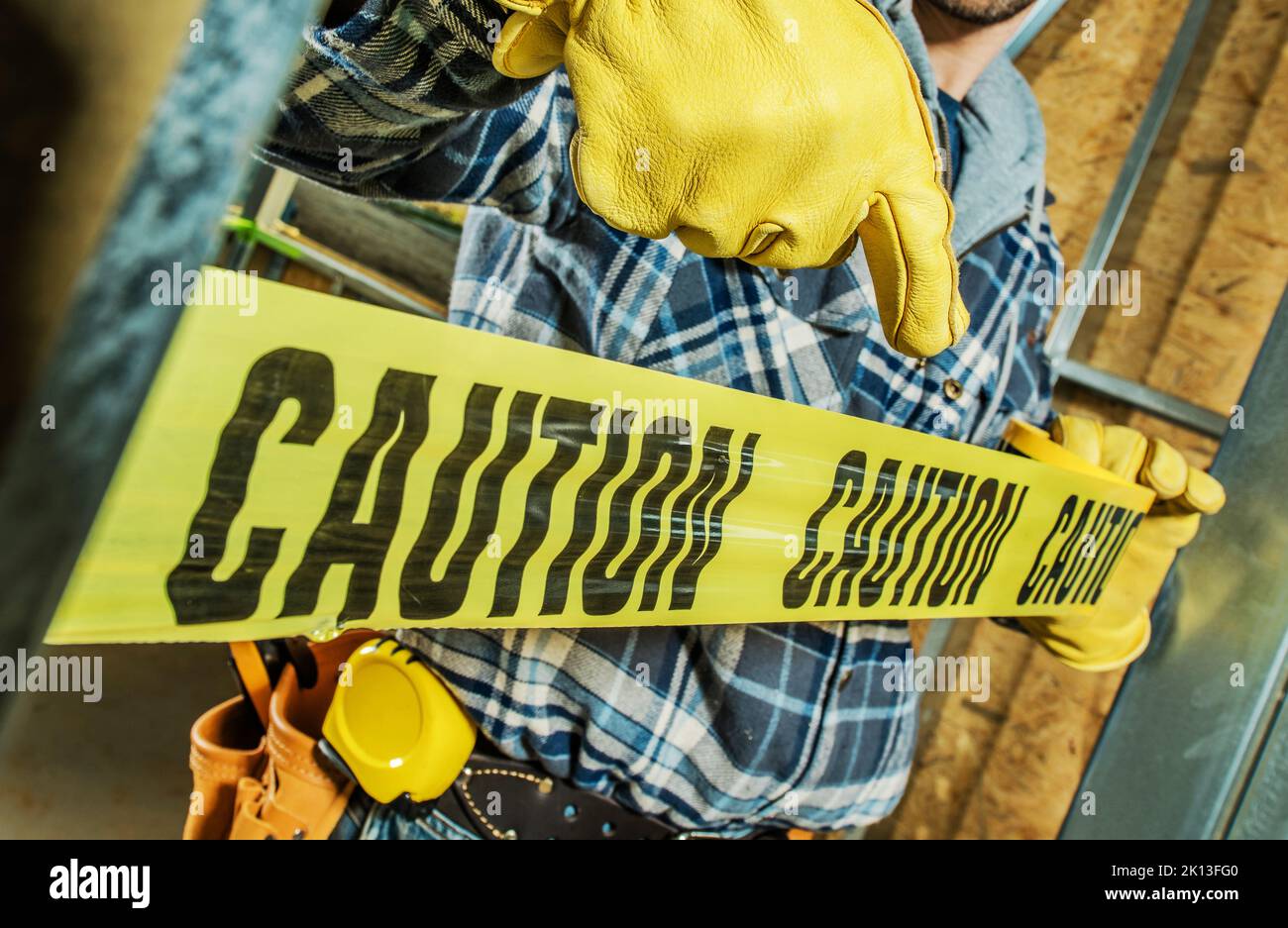 Closeup of Construction Worker Wrapping the Building Site with Yellow