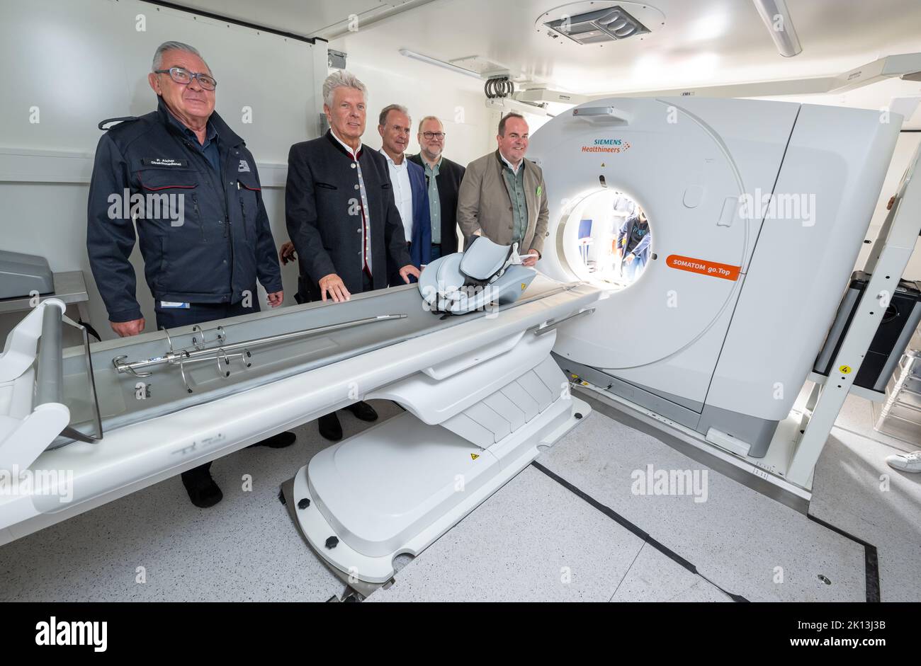 Munich, Germany. 15th Sep, 2022. Peter Aicher (l), managing director of Aicher Ambulanz, Dieter Reiter (2nd from left), Lord Mayor of the City of Munich, and Clemens Baumgärtner (r), Wiesn manager, look at a mobile CT station set up for the first time at a folk festival during the tour of the Oktoberfest grounds. The Lord Mayor, the Festival Director and other representatives of the city, the innkeepers, the showmen and the market traders take a look at the festival grounds shortly before the start of the Wiesn. Credit: Peter Kneffel/dpa/Alamy Live News Stock Photo