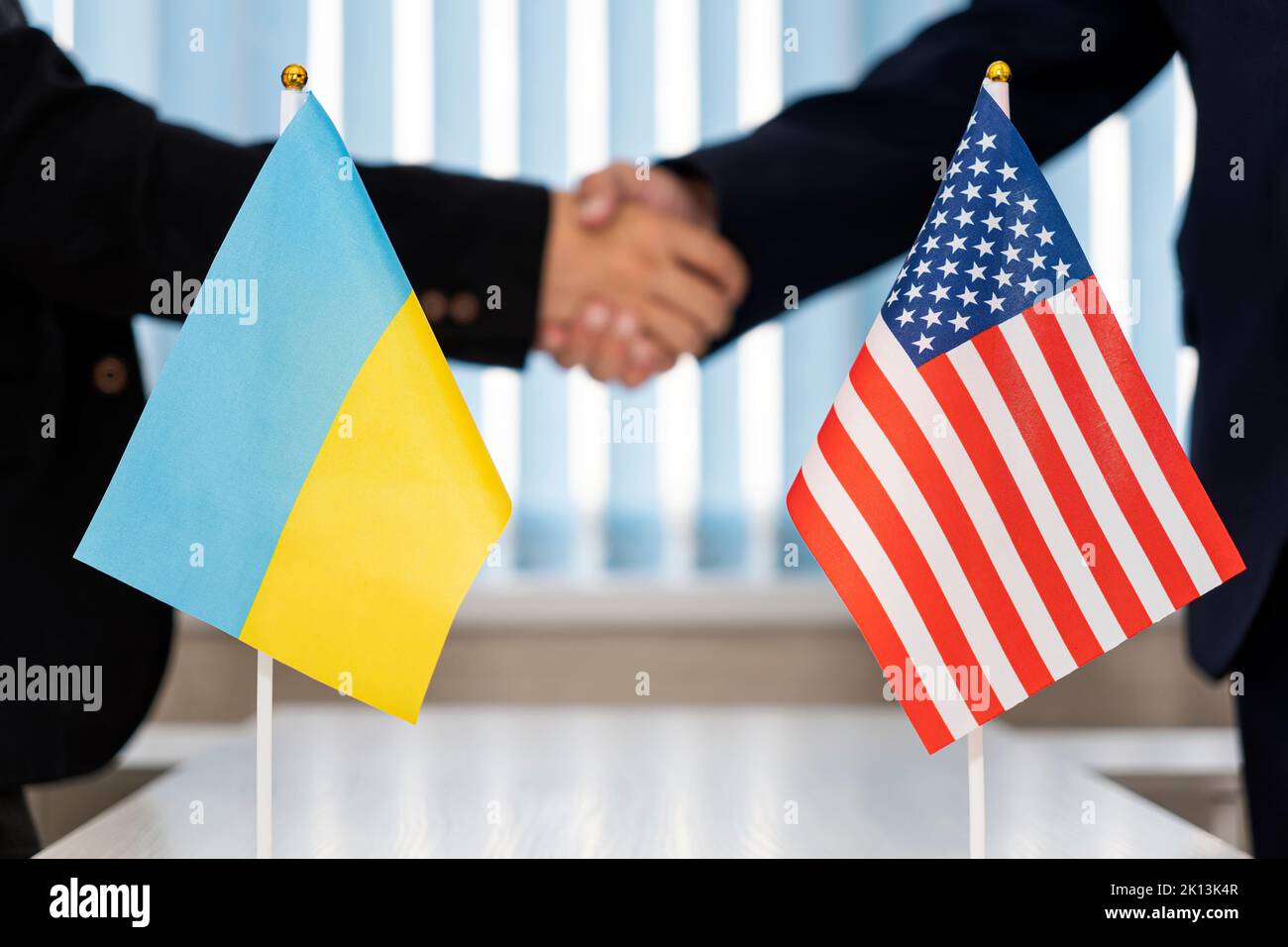 Political flags of Ukraine and United States of America on table in international negotiation room. concept of negotiations, collaboration and coopera Stock Photo