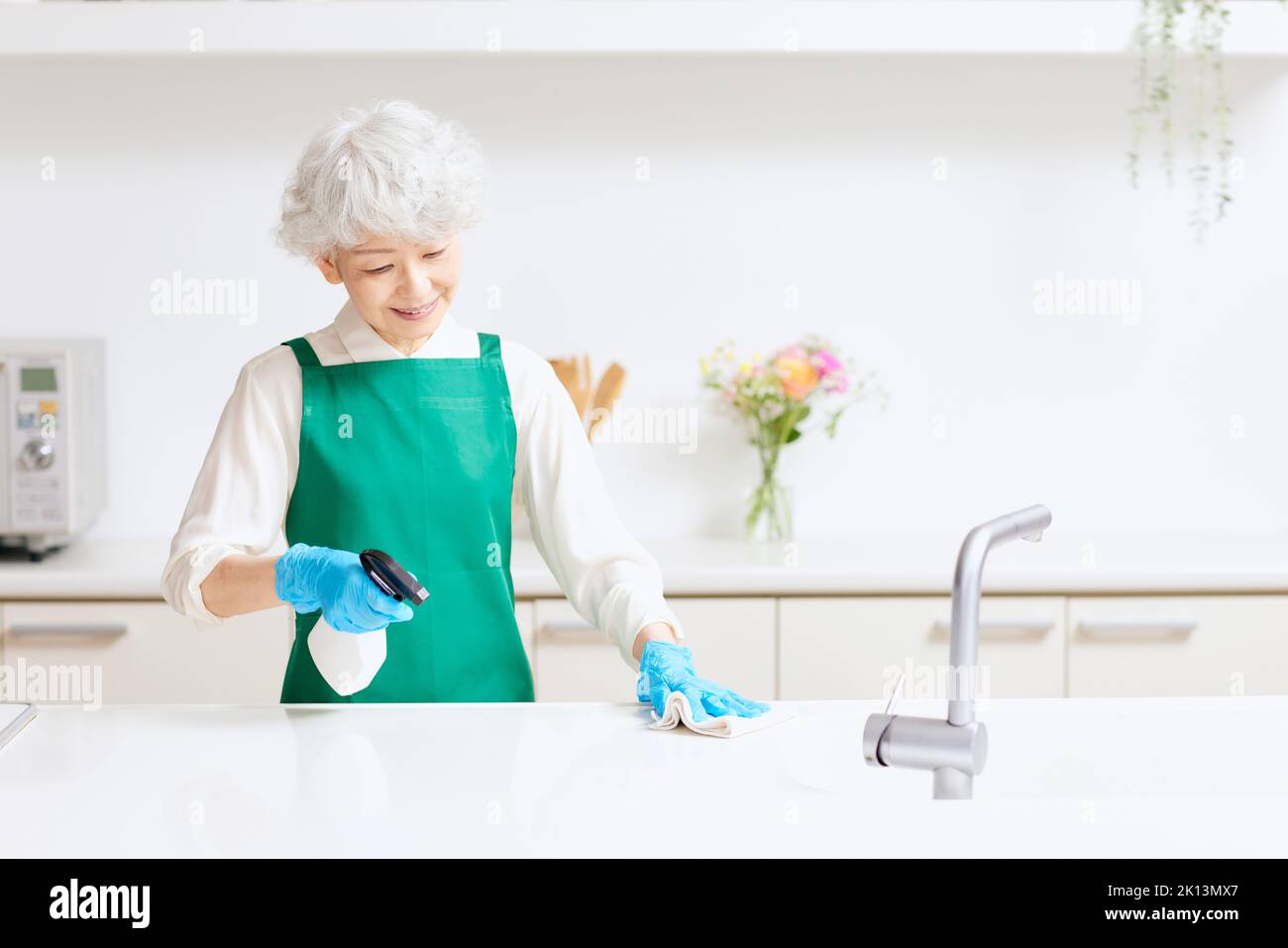 Senior woman cleaning kitchen hi-res stock photography and images - Alamy
