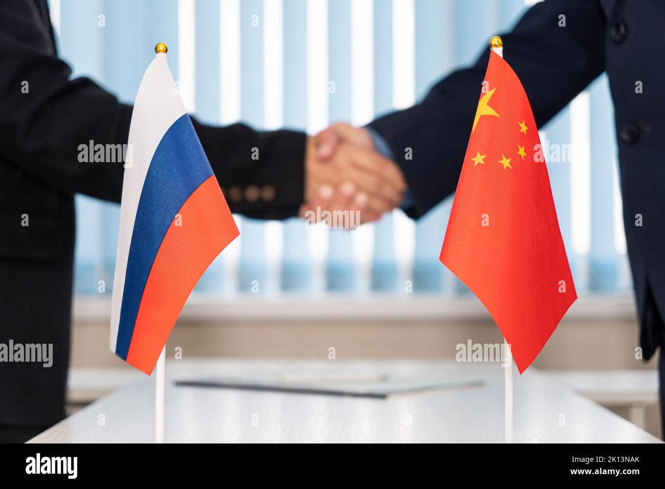Political flags of russia and chinese on table in international negotiation room. concept of negotiations, collaboration and cooperation of countries. Stock Photo