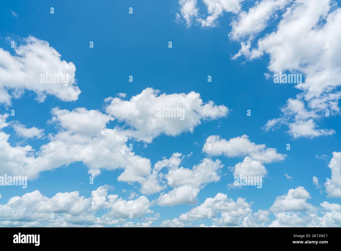 Beautiful blue sky and white cumulus clouds abstract background. Cloudscape background. Blue sky and fluffy white clouds on sunny day. Nice weather. Stock Photo