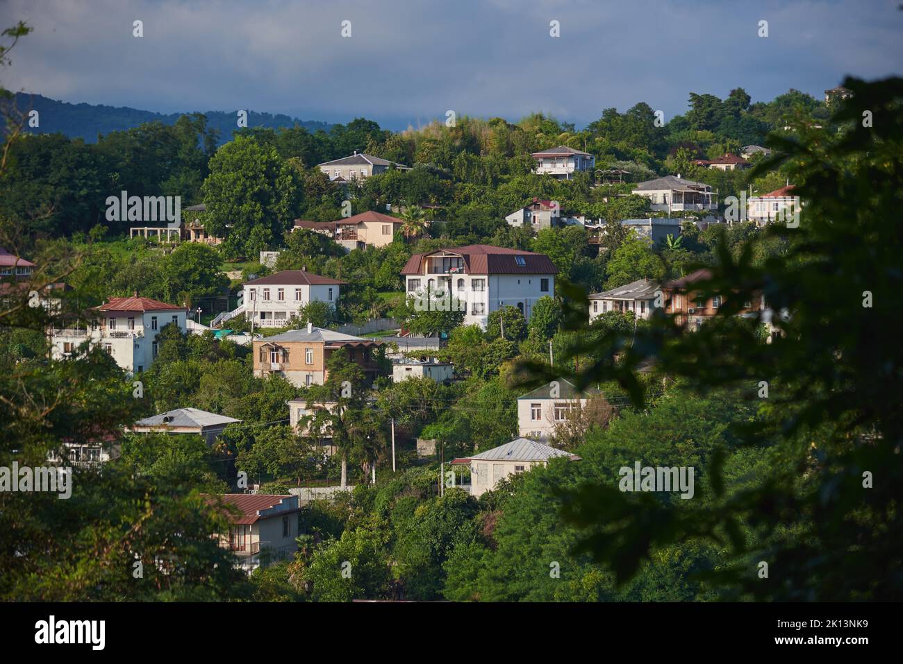 Stone white houses on the hillside among the trees. A small town on a mountain. Stock Photo
