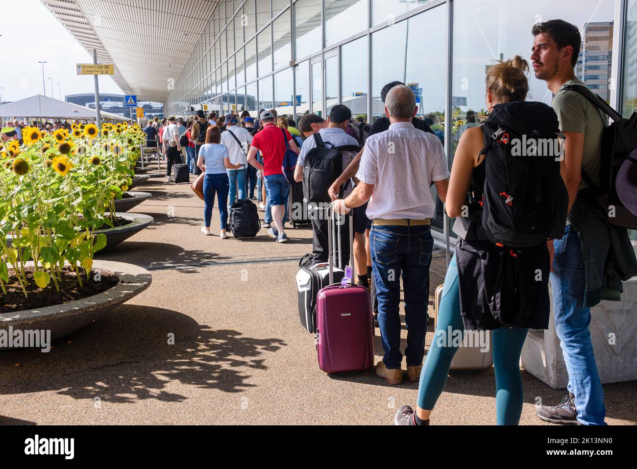 Very long queues of passengers waiting to get through security outside Schiphol Airport, Netherlands Stock Photo