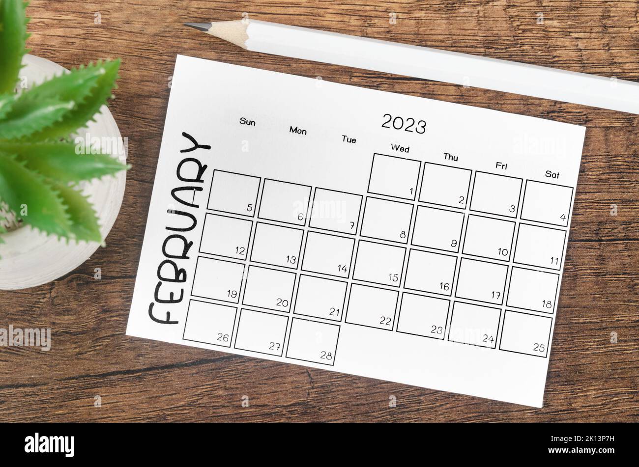 February 2023 Monthly calendar for 2023 year with pencil on wooden table. Stock Photo