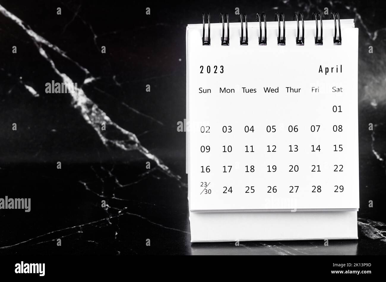 April 2023 Monthly desk calendar for 2023 year on black marble background. Stock Photo