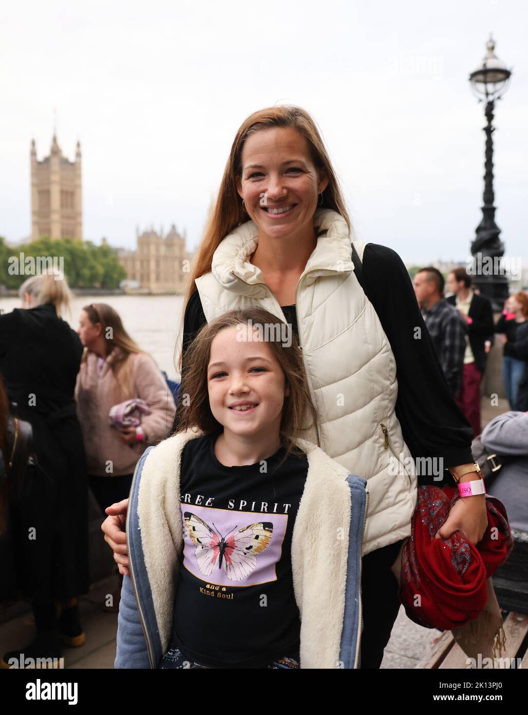 London, UK. 15th Sep, 2022. Colleen Connors and her daughter Lily (7 years old) from London stand next to a long queue on the Thames near Parliament to say goodbye to the coffin of Queen Elizabeth II laid out in Westminster Hall. The coffin containing the Queen will be laid out at the Palace of Westminster (Parliament) for four days. The British Queen Elizabeth II died on 08.09.2022 at the age of 96. (to dpa: 'Queuing for the Queen or the most British of all virtues') Credit: Christian Charisius/dpa/Alamy Live News Stock Photo