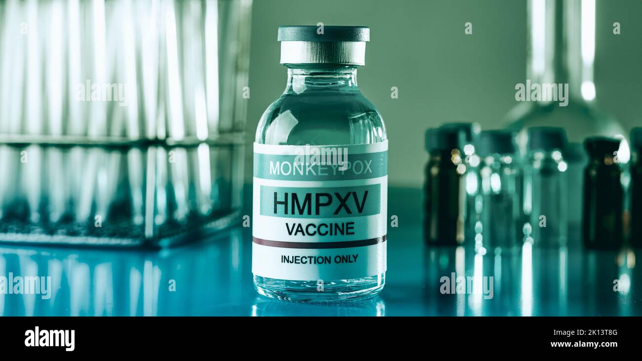 closeup of a simulated vial of monkeypox vaccine, on a laboratory table next to some tube tests, in a panoramic format to use as web banner or header Stock Photo