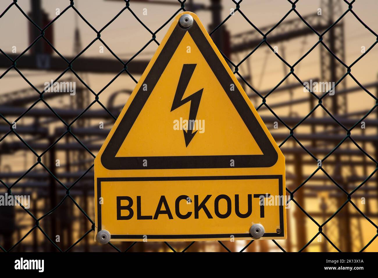 Symbolbild: Unter einem Schild das üblicherweise vor Hochspannung warnt steht das Wort Blackout Stock Photo