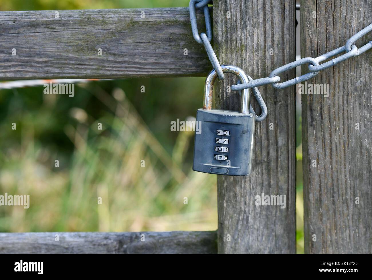 A lock on a wooden fence with a code Stock Photo