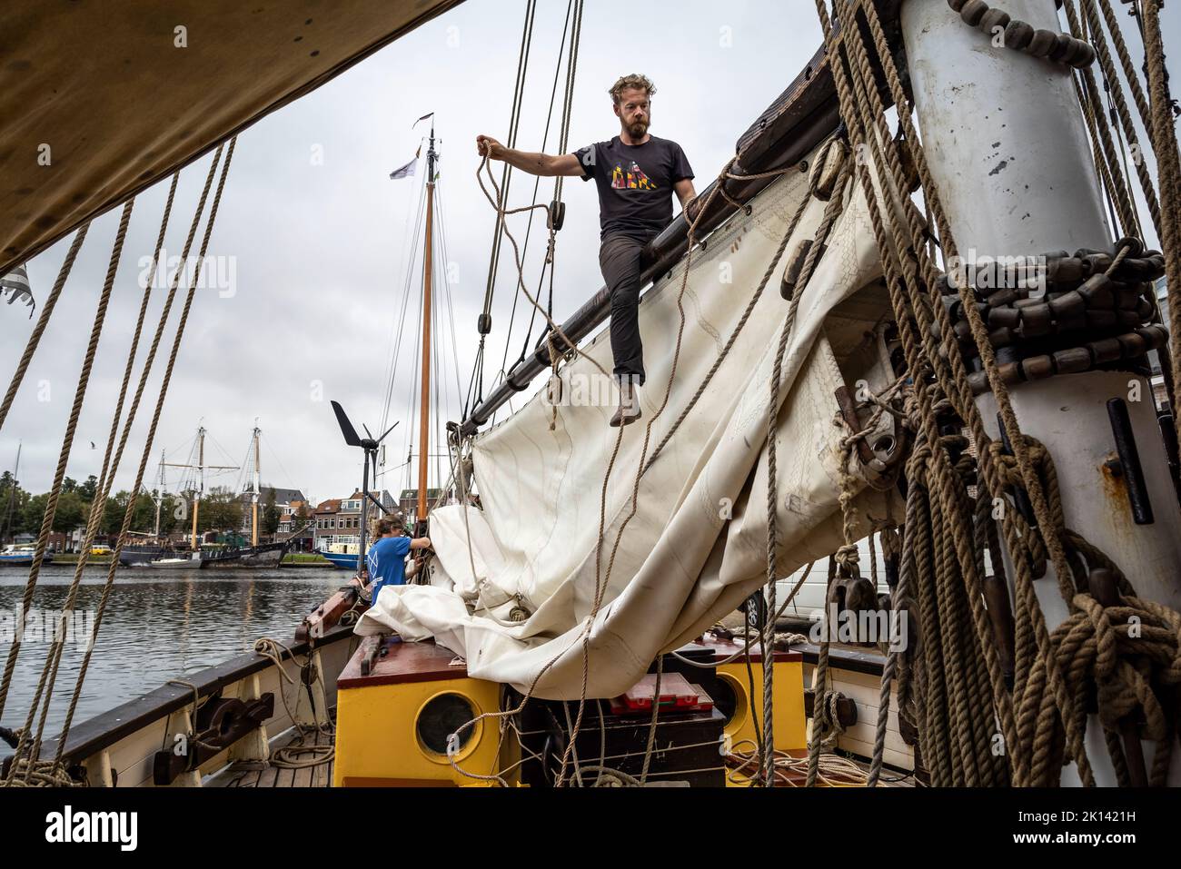 The cargo sailing vessel 'Tres Hombres' of the shipping company 'Fairtransport' has moored in its home port in Den Helder Netherlands and hoists the sails. Here it is being prepared by the crew for its next voyage. The schooner 'Tres Hombres' transports goods such as wine, coffee, chocolate and rum from the Caribbean across the Atlantic to Europe in a completely climate-neutral manner. Stock Photo