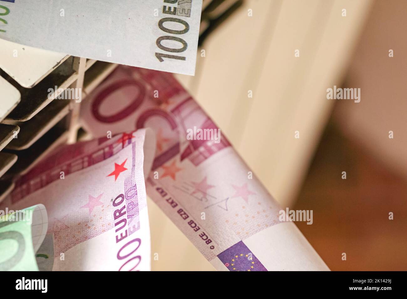 Euro banknotes in a central heating radiator, the concept of expensive heating costs in energy crisis Stock Photo