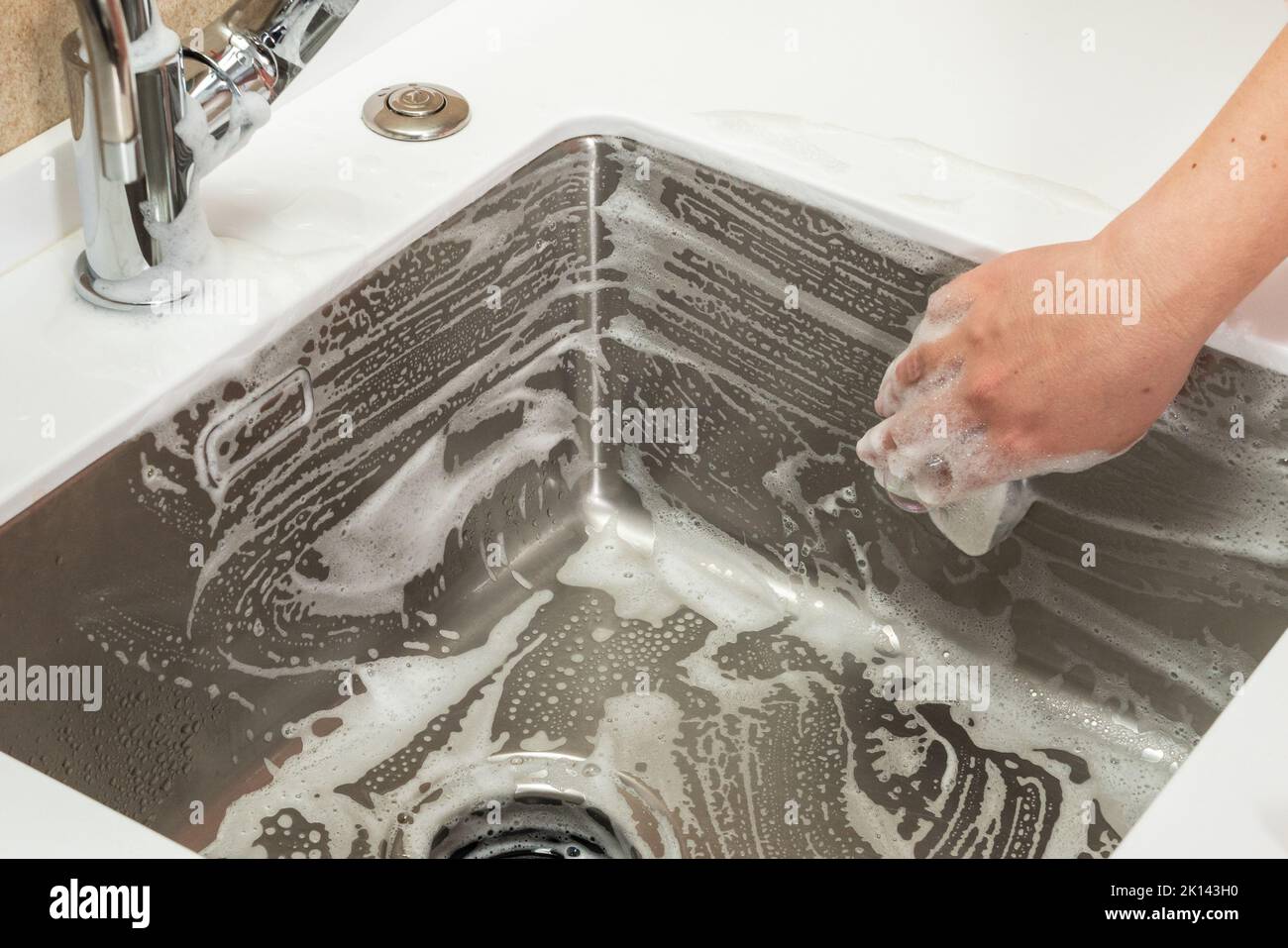 Steel sink in the kitchen in the foam of the cleaning agent Stock Photo