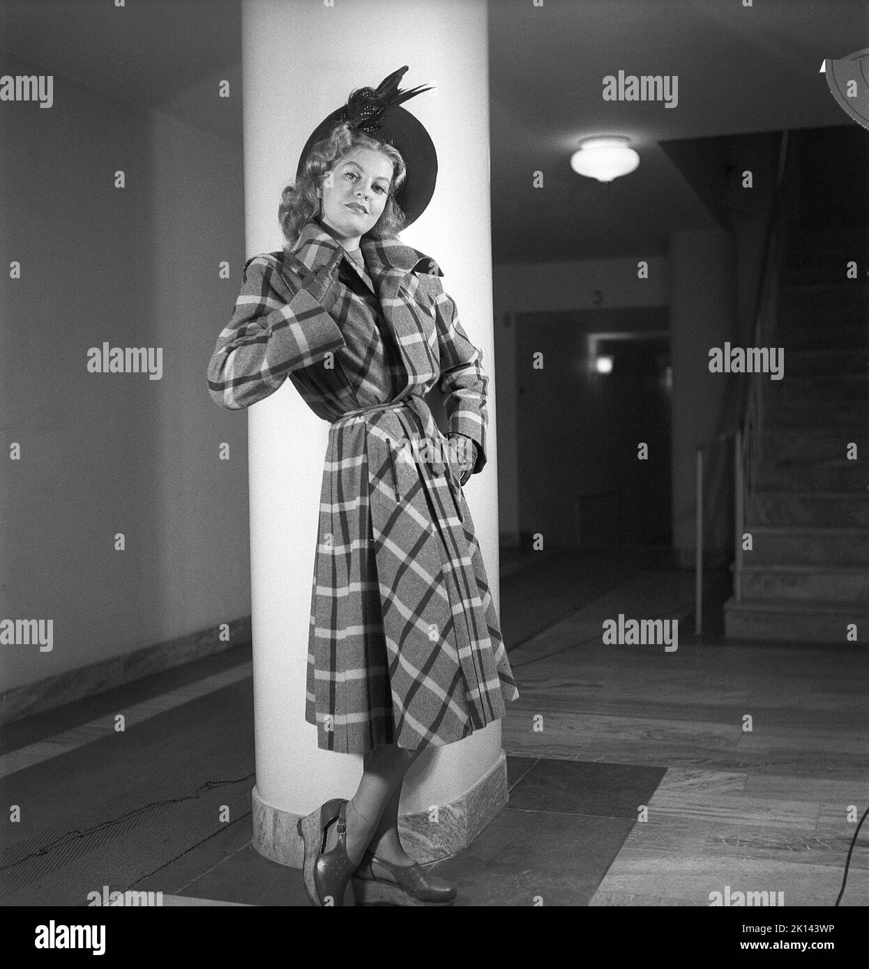 Women's fashion in the 1940s. A young woman photographed for a ladies magazine to show the women's fashion of 1945. The female model is wearing a coat in a fabric patterned with light and dark stripes with a matching hat. Sweden 1945.  Kristoffersson Ref R2-3 Stock Photo
