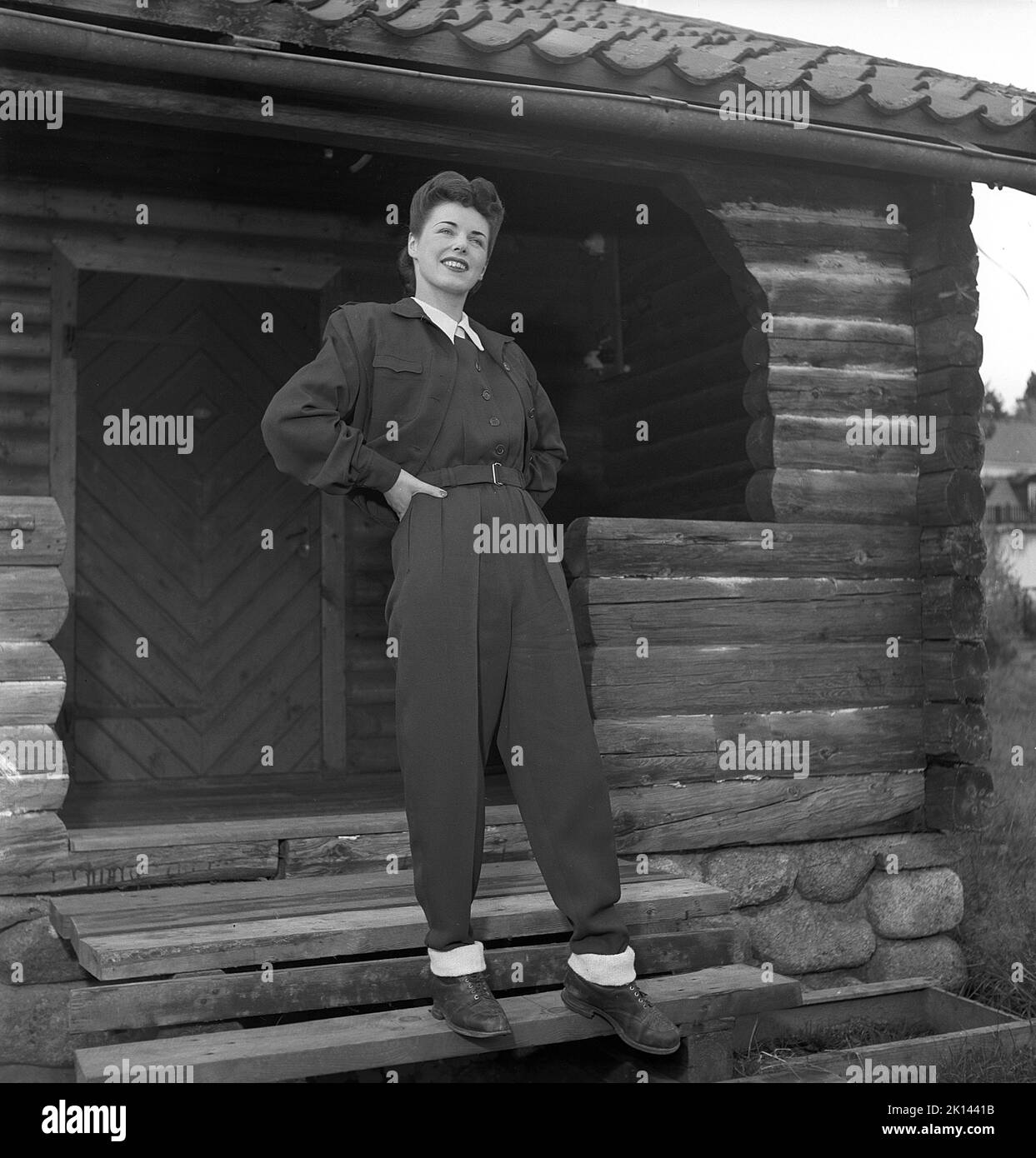 Women's fashion in the 1940s. A young woman photographed for a ladies magazine to show the women's fashion of 1945. The female model is wearing the typical sports clothes of the time that either could be worn when skiing or at leisure. The trousers are made in the typical elastic synthetic fabric with a ribbon attached to it to have under the foot, in that way creating a stretched look.    Sweden 1945.  Kristoffersson Ref R6-1 Stock Photo