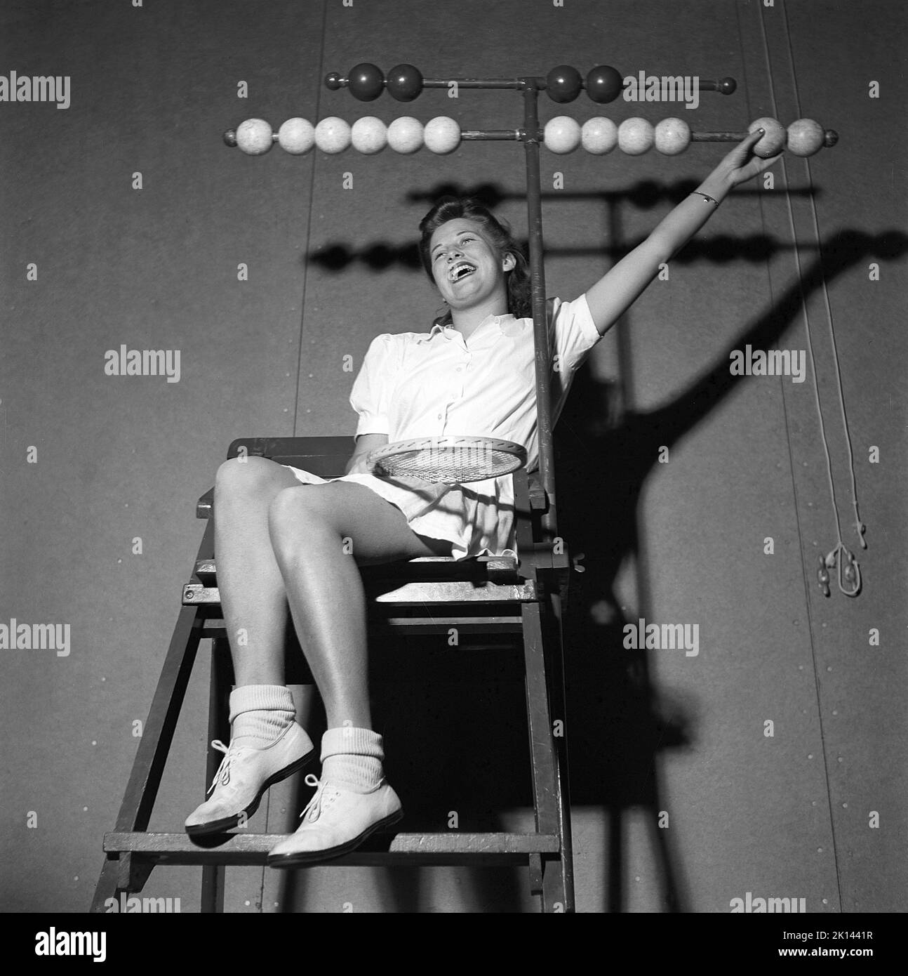 Tennis in the 1940s. A young woman is sitting in the tennis jugdge's chair. The wooden balls in bright and dark on each side are for visually mark won games and sets for each player  Sweden 1942 Kristoffersson ref M92-5 Stock Photo