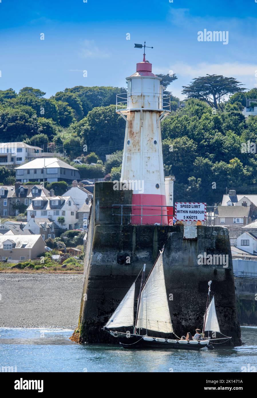 A sailing boat leaves Newlyn harbour in Cornwall, UK - the mean sea level at Newlyn, Ordnance Datum Newlyn provides the vertical datum the Ordnance Su Stock Photo