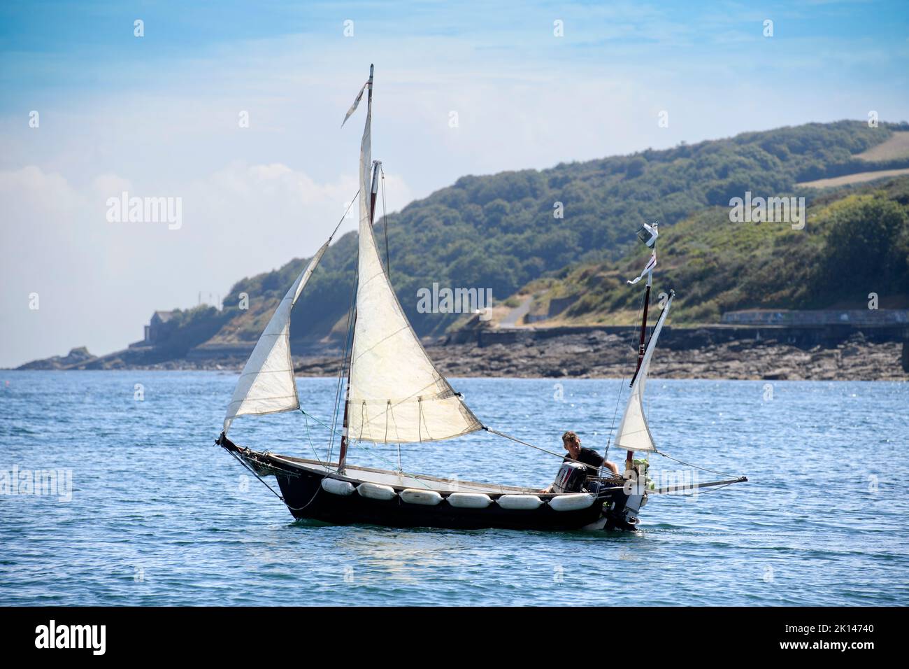 A sailing boat leaves Newlyn harbour in Cornwall, UK the mean sea