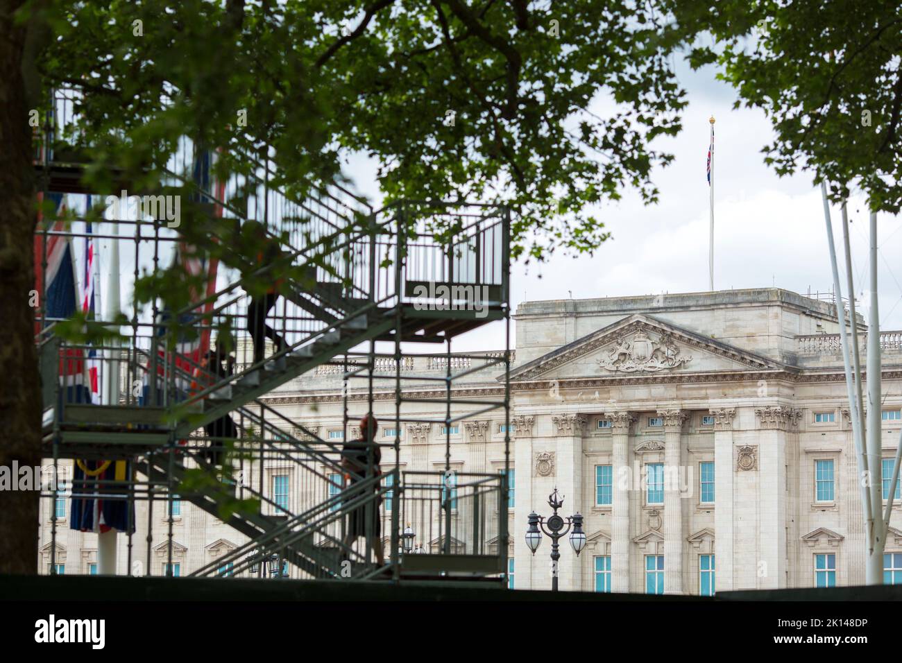 Temporary structures and workers are silhouetted against Buckingham