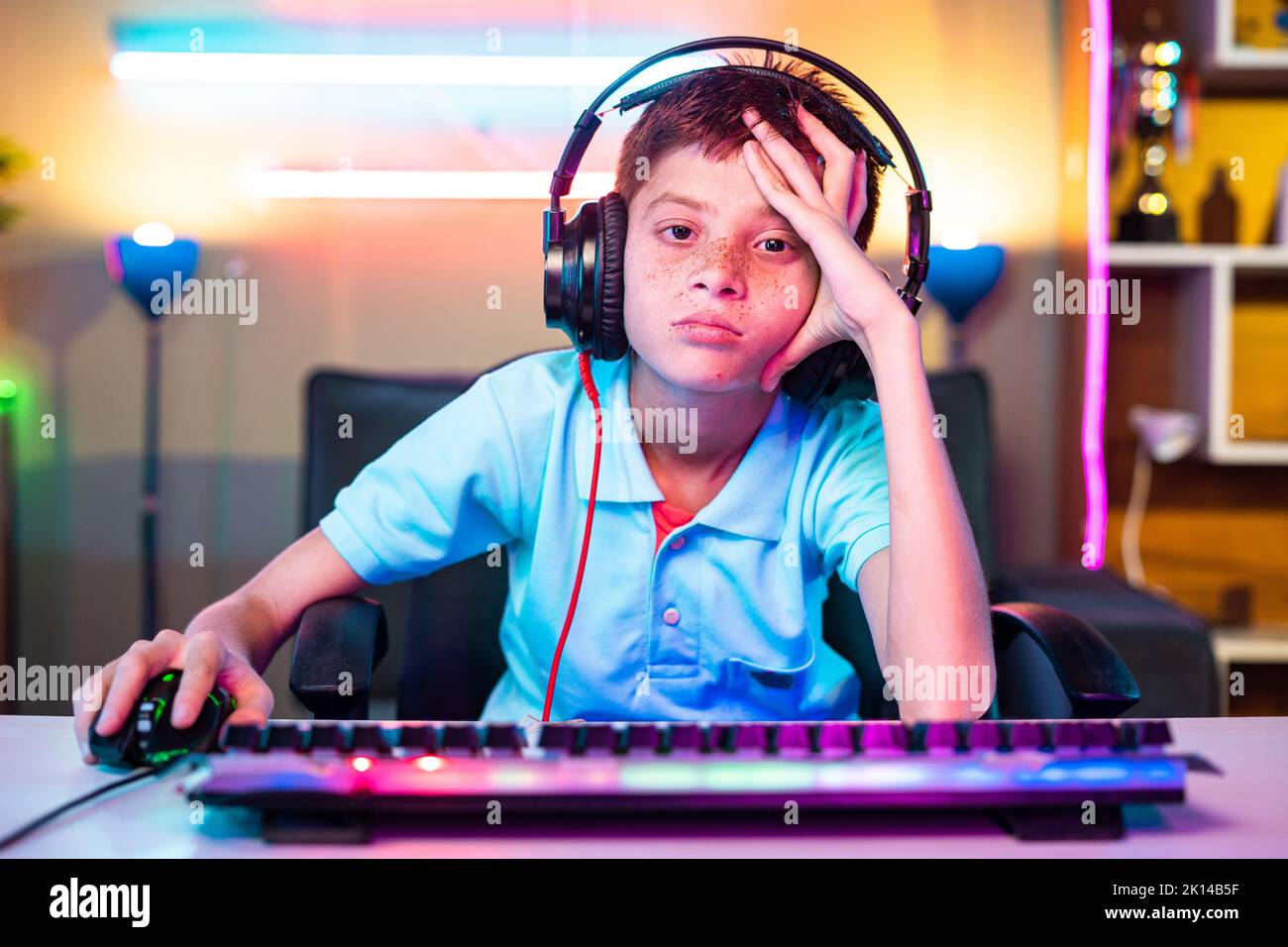 worried kid due to loss in platying video game on computer looking camera at home - concept of cyberspace, competition and entertainment Stock Photo