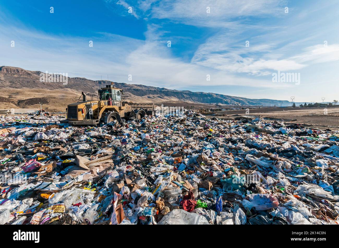 A soil compactor crushing solid waste at an active landfill Stock Photo