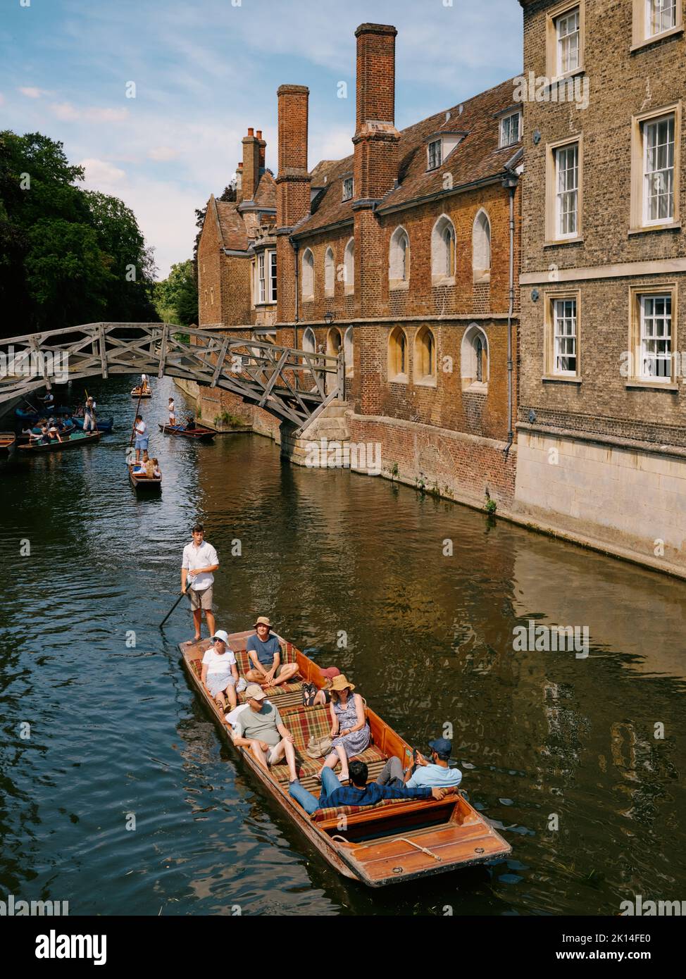 The Mathematical Bridge across the river Cam and summer tourists punting at Queens College in Cambridge Cambridgeshire England UK Stock Photo