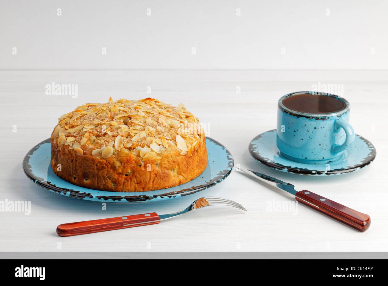 Homemade grape cake and cup of tea on white wooden table. Copyspace Stock Photo